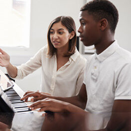 Lady Teaching Piano to Guy