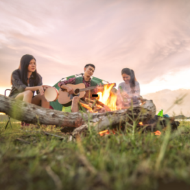 Friends playing music together outdoors on a summer day